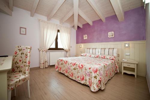 - une chambre avec un lit et un mur violet dans l'établissement Appartamenti Villa Ancora, à Castiglione della Pescaia