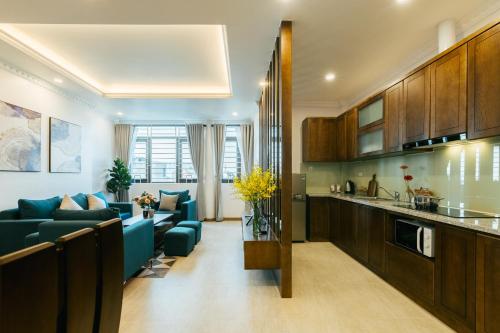 ein Wohnzimmer mit einem blauen Sofa und einer Küche in der Unterkunft My Serenity Service Apartment - West Lake in Hanoi