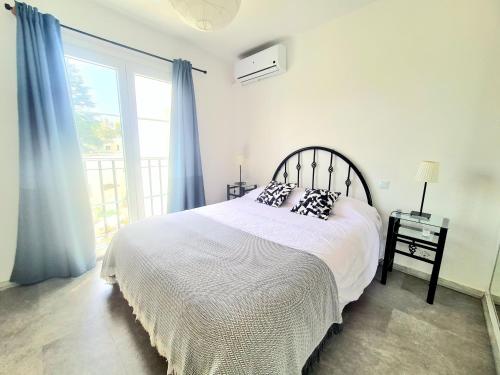 a bedroom with a bed with pillows and a window at Apartamento con vistas al Campo de Golf y Piscina in Mijas Costa
