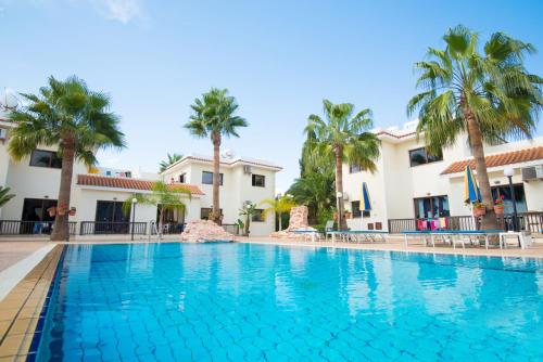 a swimming pool at a resort with palm trees at Amethyst Napa Hotel & Spa in Ayia Napa