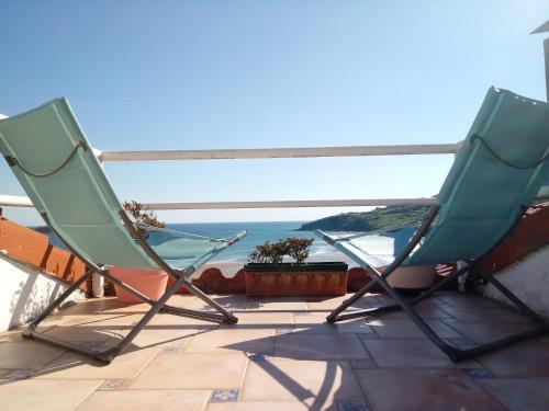two chairs sitting on a patio with a view of the ocean at Mundaka Vista Mar L-BI-52 in Mundaka