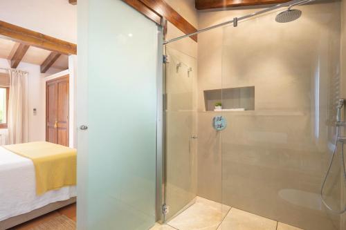 een douche met een glazen deur in een slaapkamer bij Villa Can Brullet by SunVillas Mallorca in Pollença