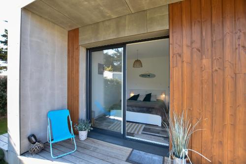 une porte en verre d'une maison avec une chambre. dans l'établissement Le Lodge, à Saint-Jean-de-Monts