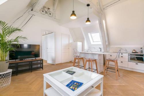 uma cozinha e sala de estar com mesa e cadeiras em Le notre dame em Dijon