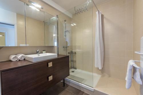 une salle de bain avec un lavabo et une douche dans l'établissement Carré du roi - Première conciergerie, à Montpellier