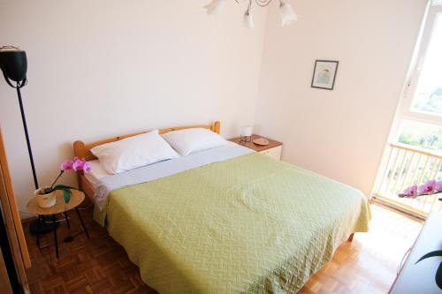 Schlafzimmer mit einem Bett mit grüner Tagesdecke in der Unterkunft Apartment Todorović - Macan in Pula