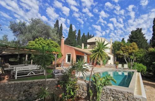 a villa with a swimming pool and a house at Xenonerantzia Country style villa in Gouvia