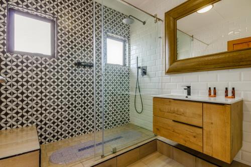 a bathroom with a shower and a sink and a mirror at The Bridge 54 in St Lucia