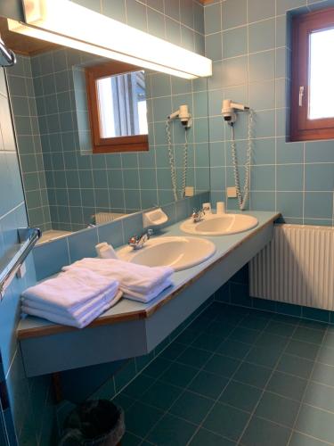 a bathroom with two sinks and a large mirror at Mai-Brunn Alm Appartements, Maibrunnenweg 34-36 in Bad Kleinkirchheim