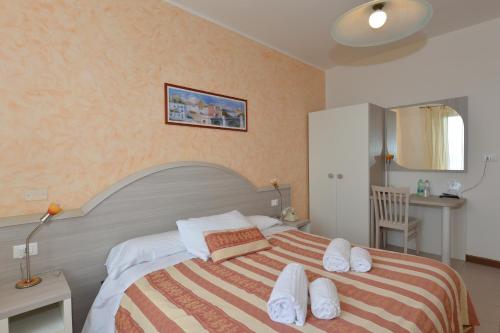 a bedroom with a large bed with a striped blanket at Hotel Panoramica in Bardolino