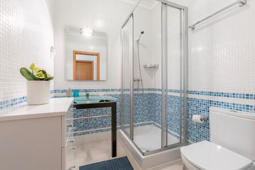 a bathroom with a glass shower and a toilet at Lagos beach condo in Lagos
