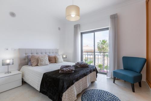 um quarto com uma cama e uma cadeira azul em Lagos beach condo em Lagos