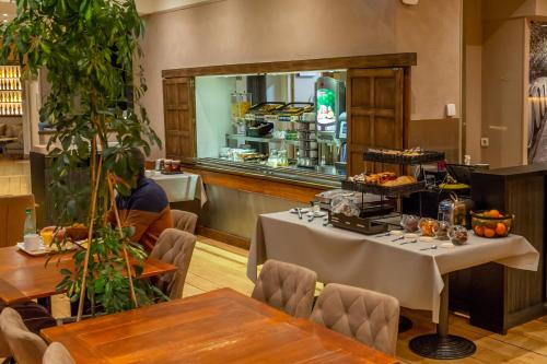 a dining room with a table with a buffet at Hôtel The Originals City Le Berry - proche centre-ville - Gare in Bourges