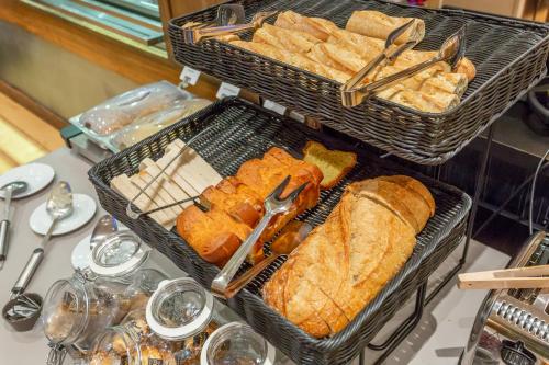 two baskets of bread and sandwiches on a table at Hôtel The Originals City Le Berry - proche centre-ville - Gare in Bourges