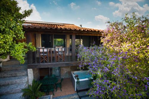 a house with a garden with purple flowers at Pedra Bela - Cozy House w/ Private Jacuzzi @ Geres in Terras de Bouro
