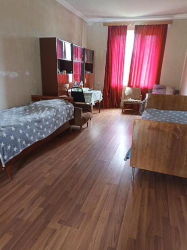 Un dormitorio con dos camas y una sala de estar. en mari, en Akhasheni