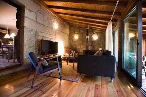 a living room with a couch and a television at Pedra Bela - Cozy House w/ Private Jacuzzi @ Geres in Terras de Bouro