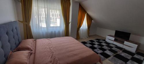 ein Schlafzimmer mit einem Bett und einem Fernseher in der Unterkunft Central Palace Iași Apart 2 in Iaşi