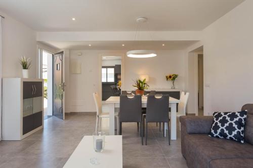 a living room and dining room with a table and chairs at Es descans in Can Picafort