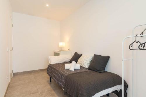 a bedroom with a bed in a white room at Es descans in Can Picafort