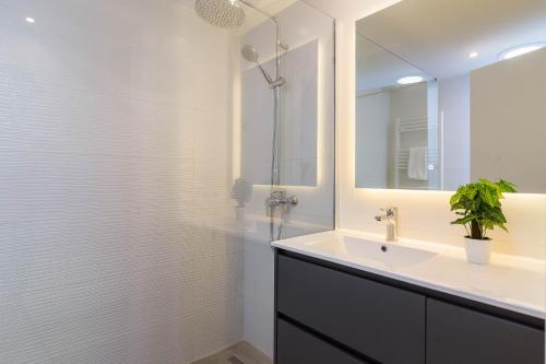 a bathroom with a sink and a shower with a mirror at Es descans in Can Picafort