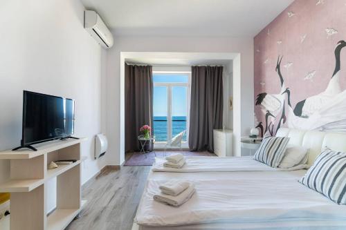 a hotel room with two beds and a tv at Rezident Eforie Nord in Eforie Nord