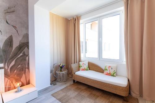 a living room with a couch and a window at Rezident Eforie Nord in Eforie Nord