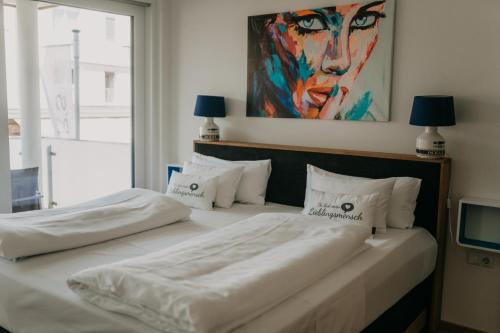 two beds in a room with a painting on the wall at Luxury Apartment Weisses Rössl Residenzen in Pörtschach am Wörthersee