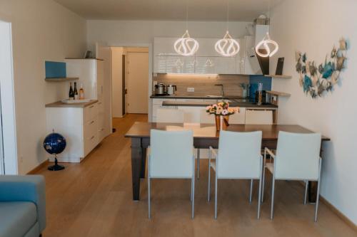 a kitchen and dining room with a table and chairs at Luxury Apartment Weisses Rössl Residenzen in Pörtschach am Wörthersee
