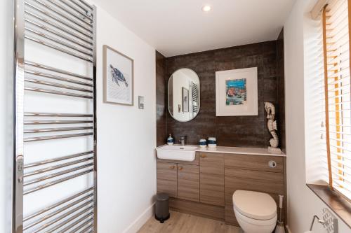 a bathroom with a toilet and a sink at No.1 The Prom in Westward Ho