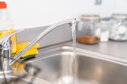 a kitchen sink with water running from a faucet at Exotic City Retreat 2 Bed 2 Bath - Free Parking in Birmingham