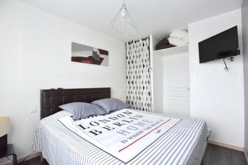 Un dormitorio con una cama con un cartel. en Le Cannois, en Le Cannet
