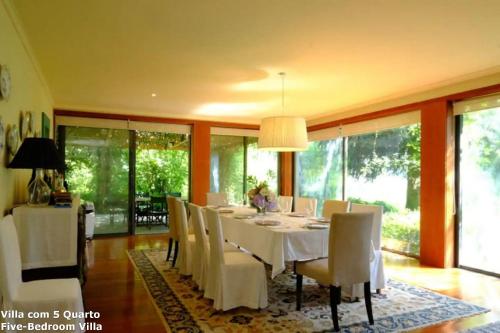 een eetkamer met een witte tafel en stoelen bij Akivillas Baião Green in Santa Cruz do Douro