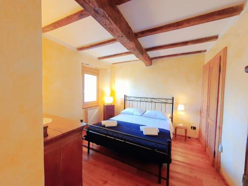 una camera con letto blu e pavimento in legno di Hellen Apartment a Verbania