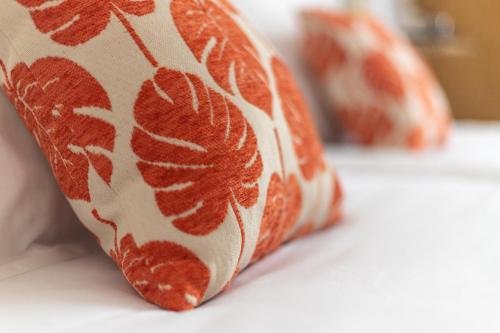 a pillow with a leaf pattern on it on a table at Hôtel Porte Mars Reims Gare Centre Arena in Reims