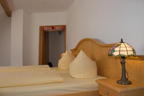 a bedroom with a bed with a lamp on a table at Landgasthof Rebstock in Sulzburg