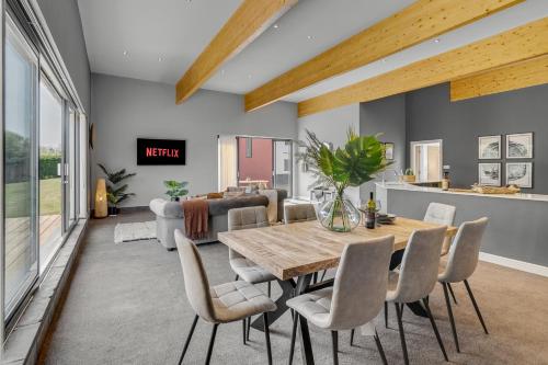 a dining room and living room with a table and chairs at Fen Lane Lodge in Snetterton