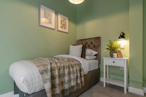 a bedroom with a bed and a table with a lamp at 4-Bed Countryside Retreat Near Thetford Forest in Snetterton