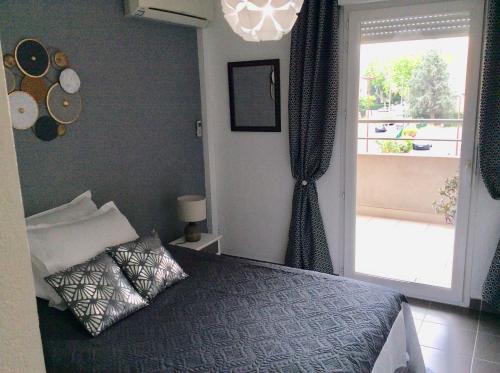 1 dormitorio con cama y ventana grande en Bord de mer en Fréjus