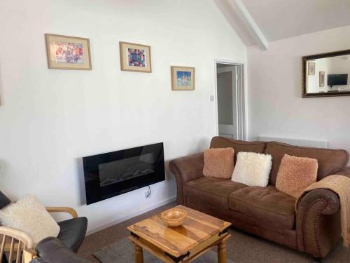 a living room with a couch and a flat screen tv at Large property which is all about location, location , location ! Lovely Comfortable 2 bedroom flat which is spacious and one of the best value properties of this size so close to the sea , beaches and restaurants 1 min to the sea ! in Lyme Regis