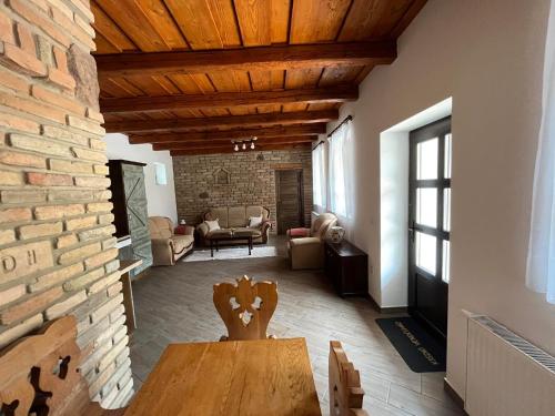 a living room with a table and a brick wall at Kisdió Vendégház in Dég