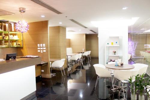 a restaurant with white chairs and tables in a room at Baiyoke Suite Hotel in Bangkok