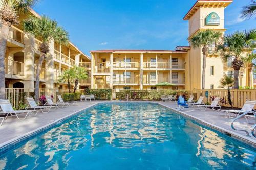 a swimming pool in front of a hotel with palm trees at La Quinta Inn by Wyndham Orlando Airport West in Orlando