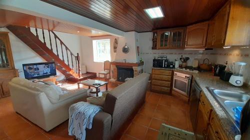 a living room with a couch and a kitchen at Casa da Magnólia in Raposeira