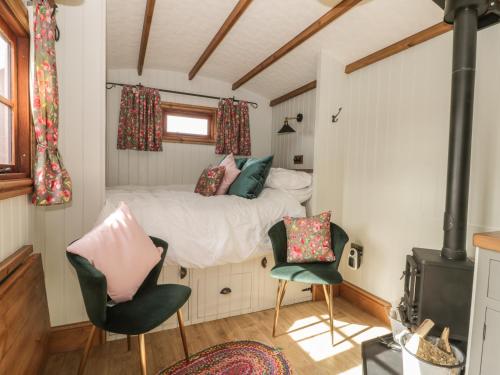 a small bedroom with a bed and two chairs at Ewes Welcome in Cottingham