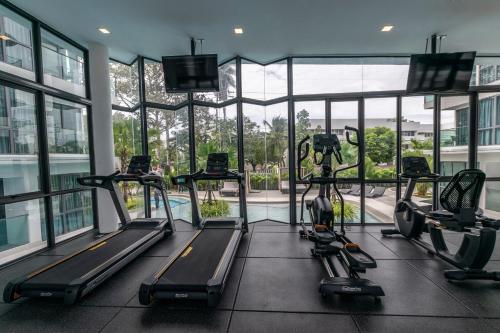 a gym with several tread machines in a building at Sea Zen Condominium Bang Saray in Bang Sare