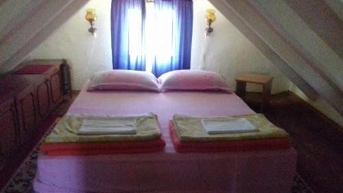 a bedroom with a bed with pink sheets and a window at Dusica in Vrnjačka Banja