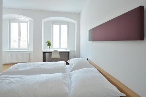 
a white bed sitting in a room next to a window at Hotel zum Goldenen Schiff in Enns
