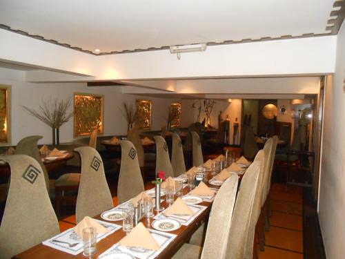 a dining room with a long table and chairs at Lytton Hotel in Kolkata