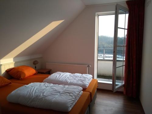 two beds in a room with a large window at luxury holiday home in Cochem for 7 people in Ediger-Eller